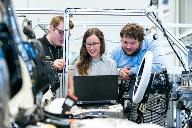 Engineers reviewing vehicle software together in an automotive workshop