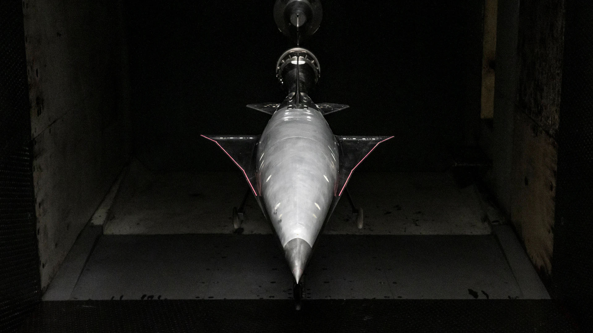 Aircraft model undergoing aerodynamic testing in a wind tunnel