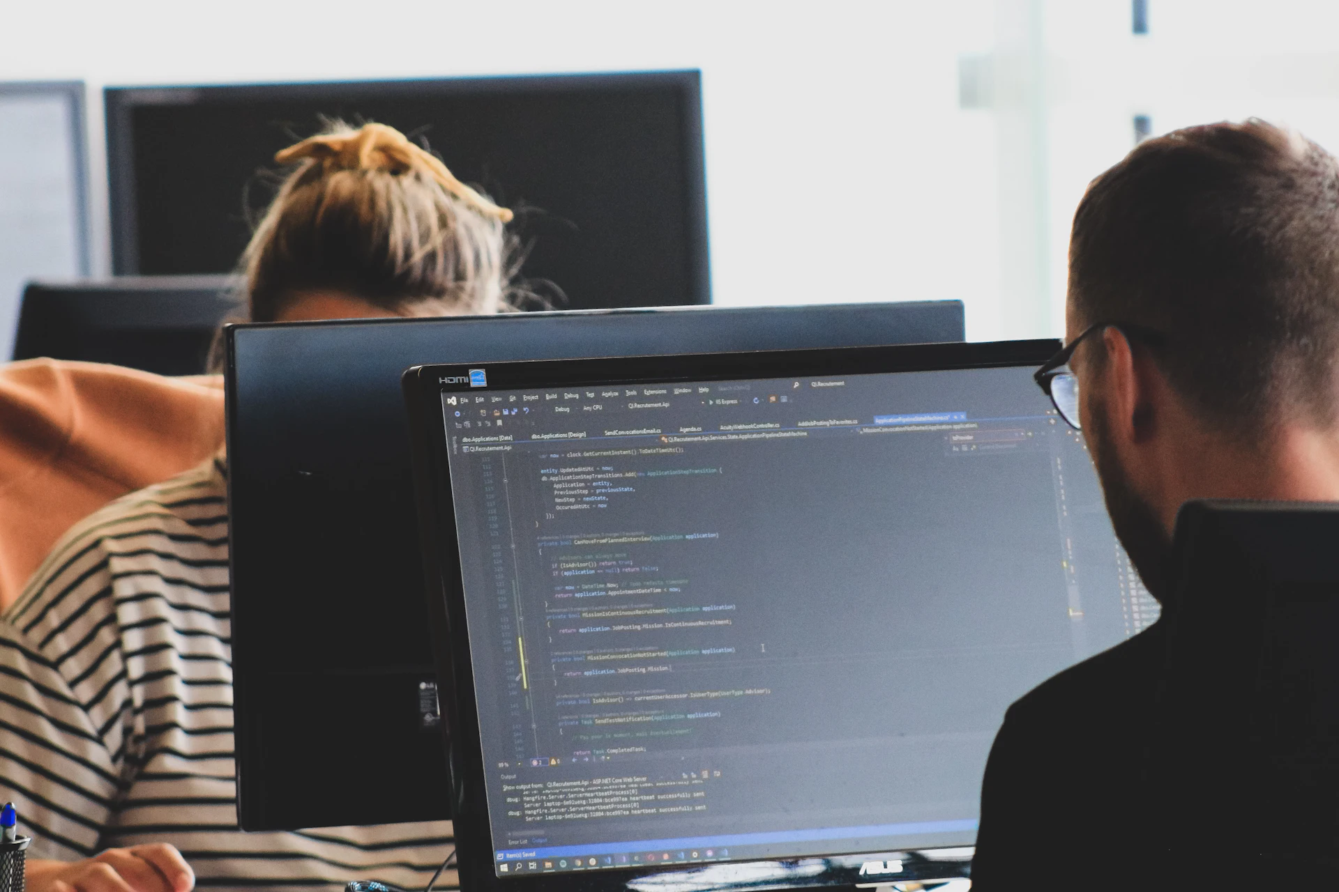Software engineers reviewing code at computer monitors