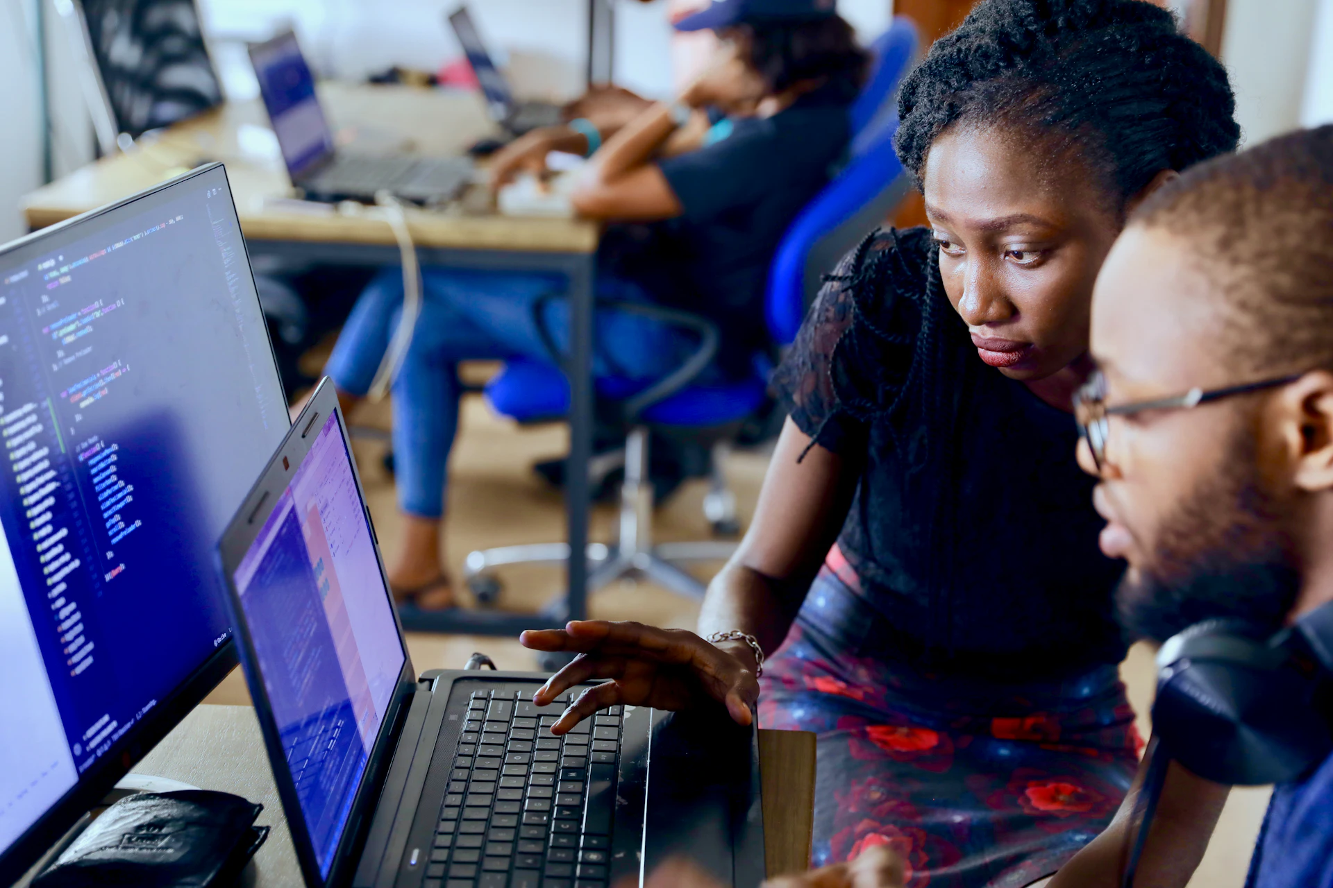 Developers collaborating on software at a shared workstation